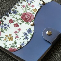 Wire-bound notebook with floral decoration and snap close