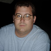 Husky man with short brown hair and glasses