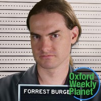 Mugshot of a brown-haired man with the Oxford Weekly Planet logo in the foreground