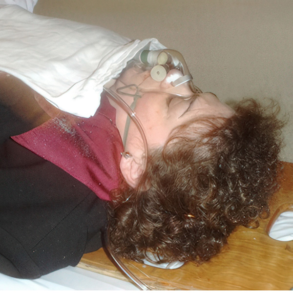 What caused Diane Coates to collapse? Woman lying on a gurney with an oxygen mask over her face