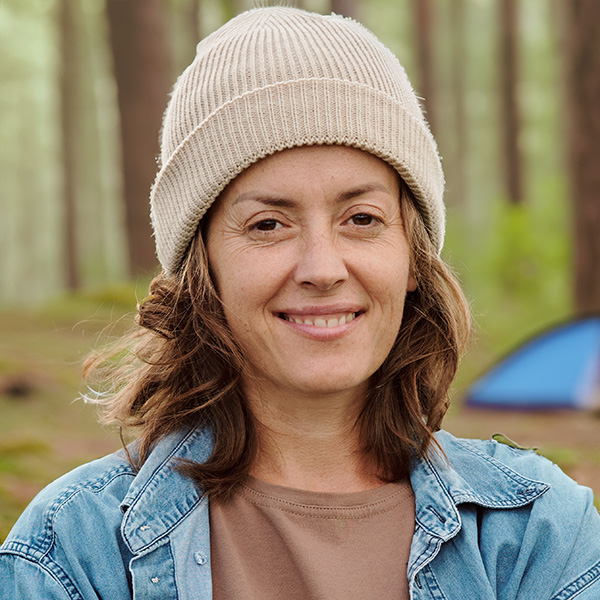 Smiling woman with shoulder-length dark hair wearing a knit hat