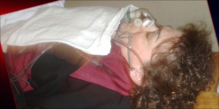 Woman lying on a gurney with an oxygen mask on her face