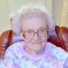 Elderly woman with white hair and glasses