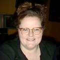 Smiling woman with brown hair and glasses