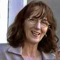 Smiling woman with glasses and shoulder-length dark hair