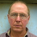 Man with dark blond receding hair and glasses