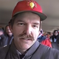 Man with brown hair and mustache wearing a red baseball cap