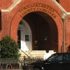 Photo of the entrance to a red brick building with "Yoknapatawpha County Coroner's Office" 