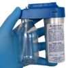 Gloved hand holding a spraying device canister