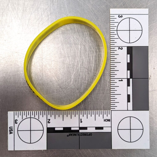 A yellow wrist band with a ruler to show scale